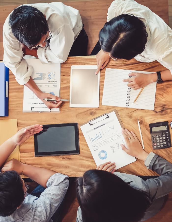 group of people around a desk discussing projects