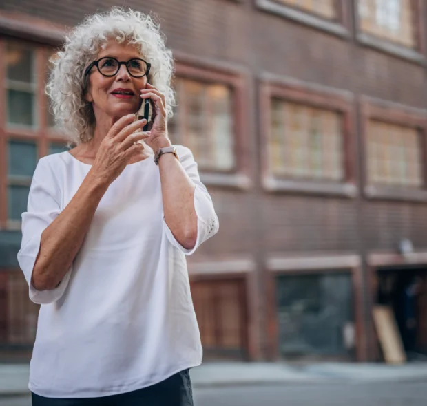 panasonic flip phone for elderly being used by a lady in the street